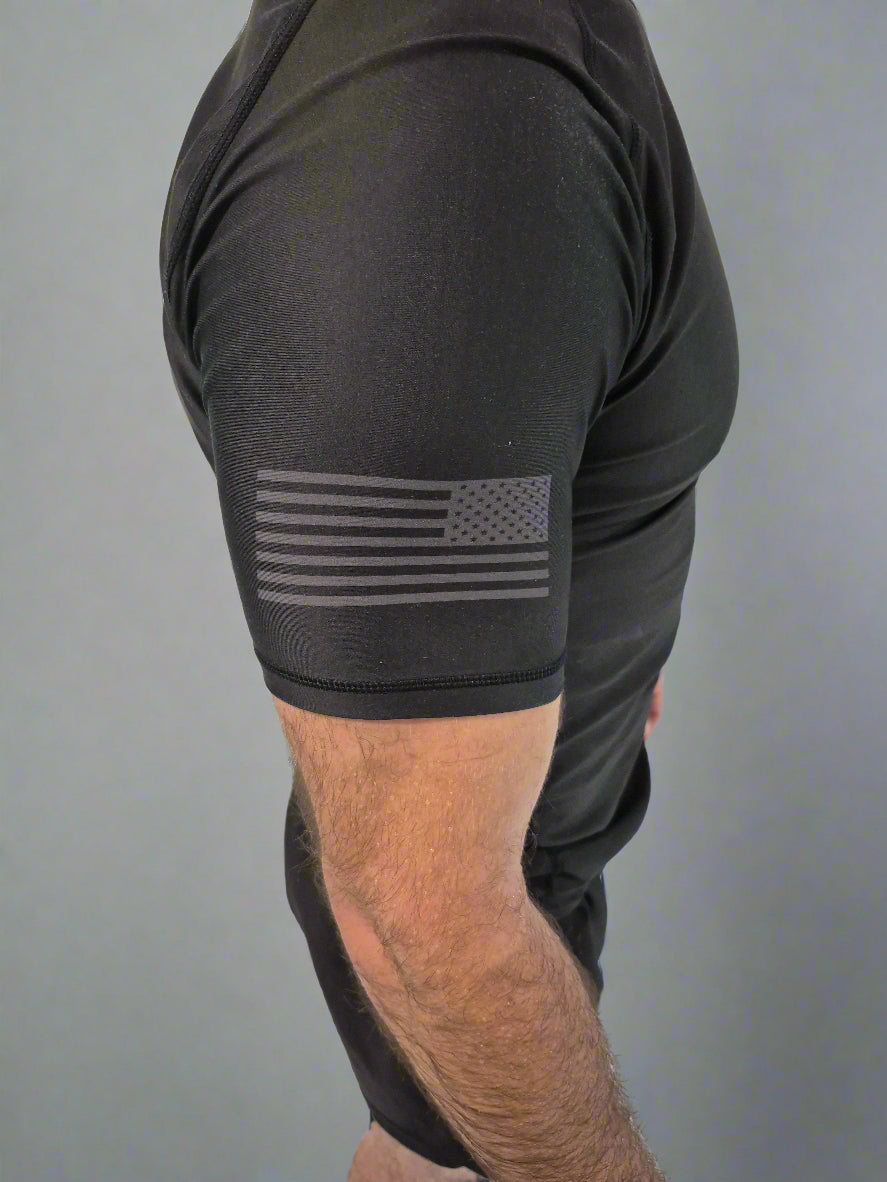 Person wearing a black sleeveless shirt with an American flag design on a white background
