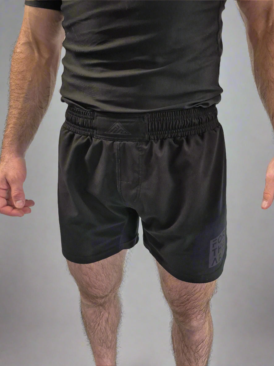 Person wearing black athletic shorts with a brand logo on a white background