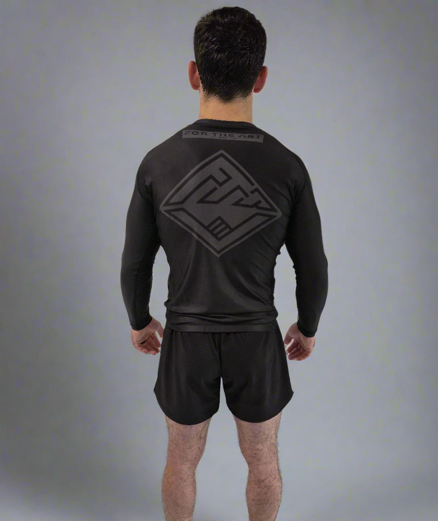 Person wearing a black athletic outfit with a logo on the back against a gray background