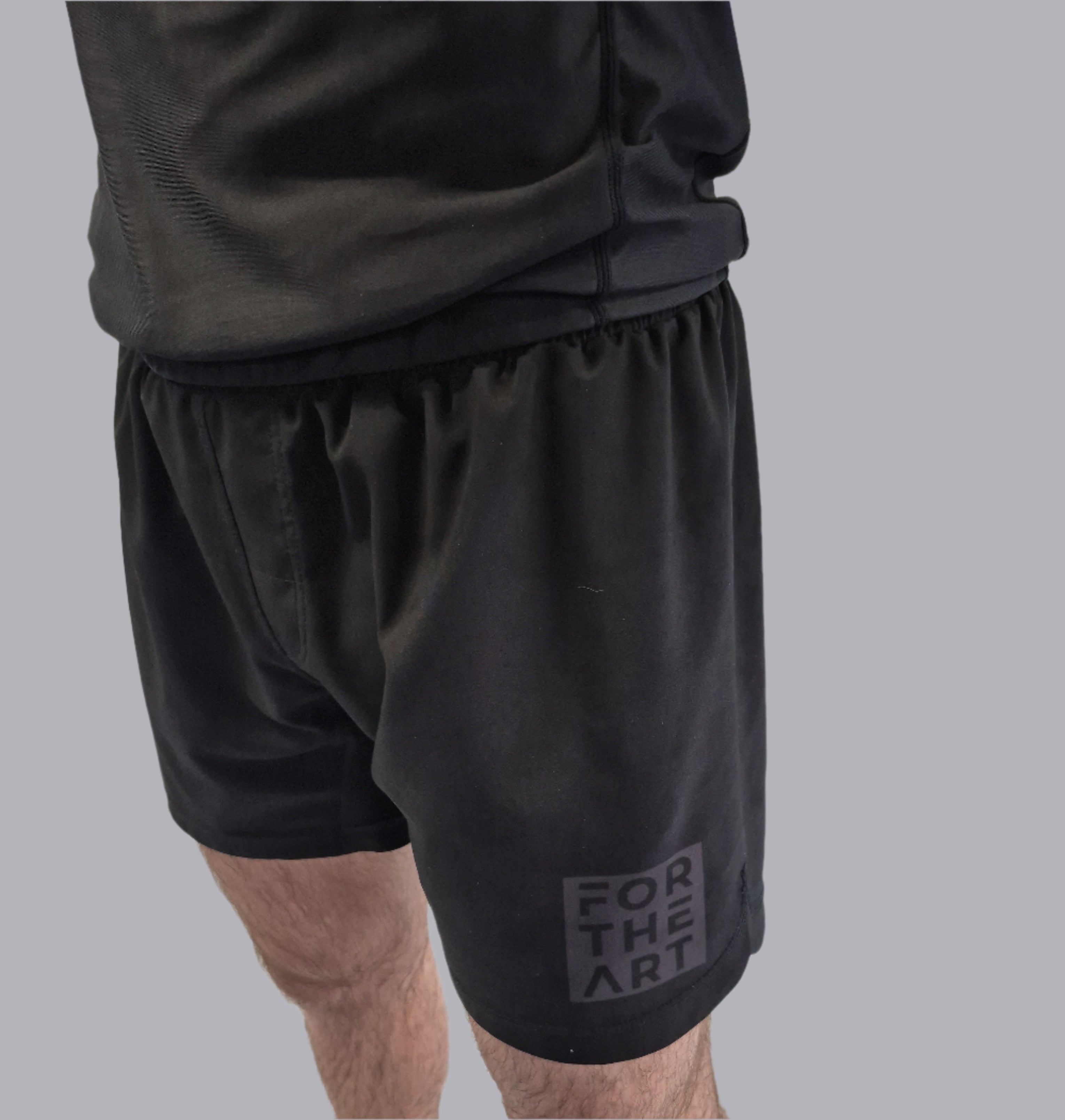 Person wearing black shorts with 'For The Win' logo on a white background