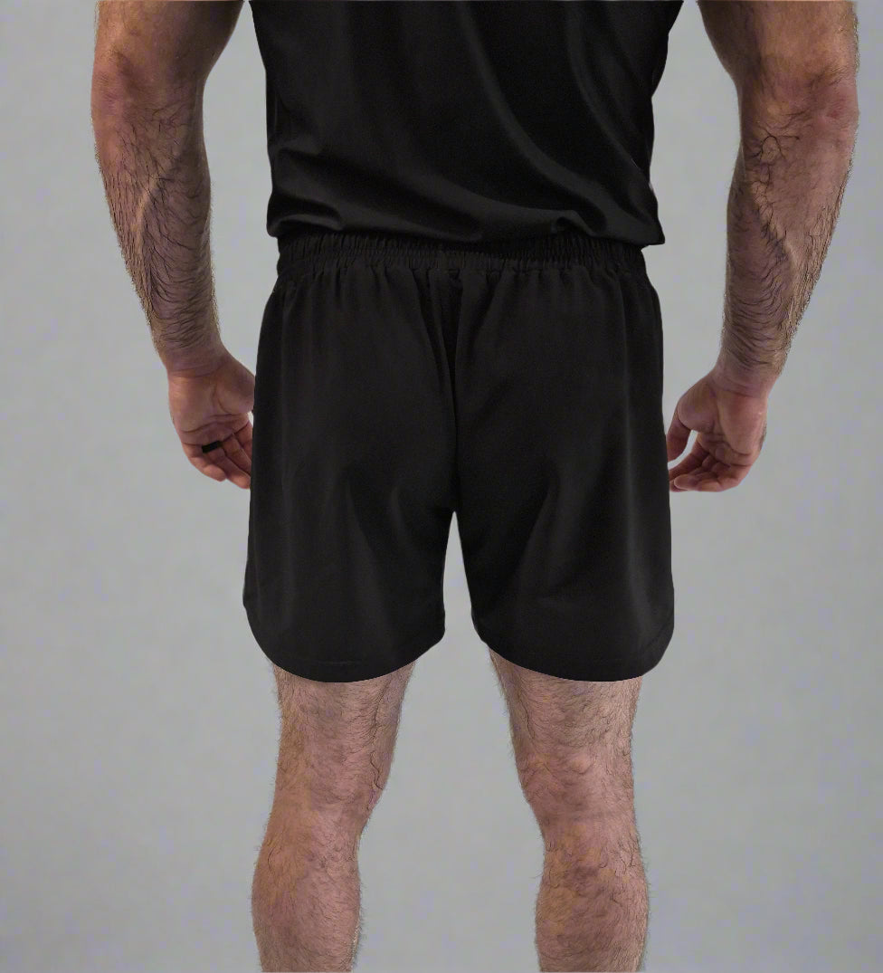Person wearing black shorts on a white background